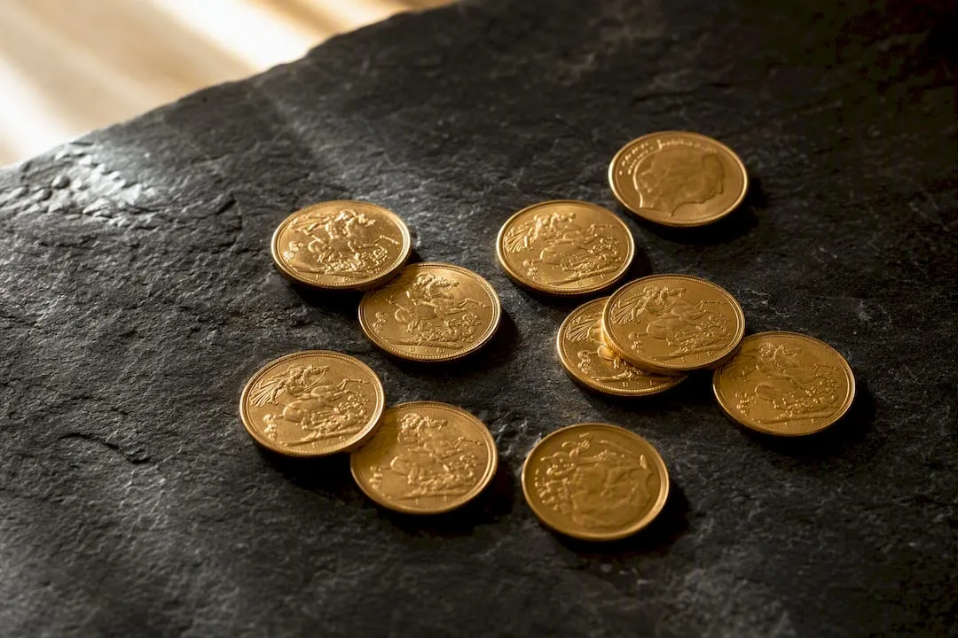 Sovereign gold coins on dark stone surface