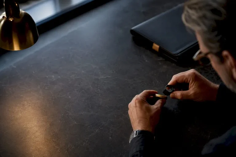 Investor examining cropped gold coin edge